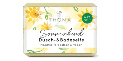 rechteckige, gelbliche Seife mit blumiger Verpackung und Aufschrift Sonnenkind, Dusch und Badeseife mit Bio Hanfsamenöl von der Naturseifen Manufaktur Uckermark.