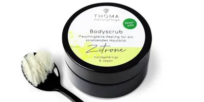 Runde, schwarze Dose mit weiß-gelber Aufschrift Bodyscrub Zitrone, Feuchtigkeitspelling mit Meersalz und Zitronenoel, handgefertigt und vegan von der Naturseifen Manufaktur Uckermark.