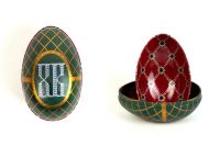 Zwei Metalldosen im Fabergé-Stil, eine geschlossen mit grün-goldenem Muster und eingeprägter Ziffer, die andere geöffnet mit rotem Innenmuster und goldenen Verzierungen, von der Naturseifen Manufaktur Uckermark.