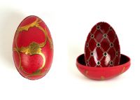 Zwei Metalldosen im Fabergé-Stil, eine geschlossen in Rot mit goldenen Ornamenten und geschwungenen Verzierungen, die andere geöffnet mit rotem Innenmuster und goldenen Details, von der Naturseifen Manufaktur Uckermark.