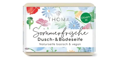 recteckige, cremefarbene Seife mit blumiger Verpackung und Aufschrift Sommerfrische, Olivenoelseife mit Mandelöl und Aloe Vera von der Naturseifen Manufaktur Uckermark.