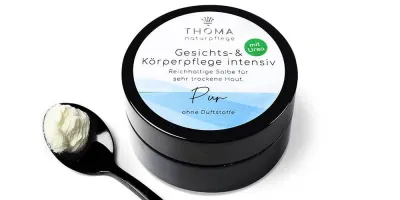 Runde, schwarze Dose mit weiß-blauer Aufschrift Gesichts und Körperpflege intensiv Pur, reichhaltige Salbe mit Urea für sehr trockene Haut ohne Duftstoffe von der Naturseifen Manufaktur Uckermark.